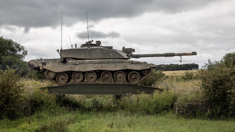 A Challenger 2 tank carefully crosses an obstacle crossing after a temporary bridge has been put down during Exercise IRON CYCLONE 24072023 CREDIT MOD.jpg