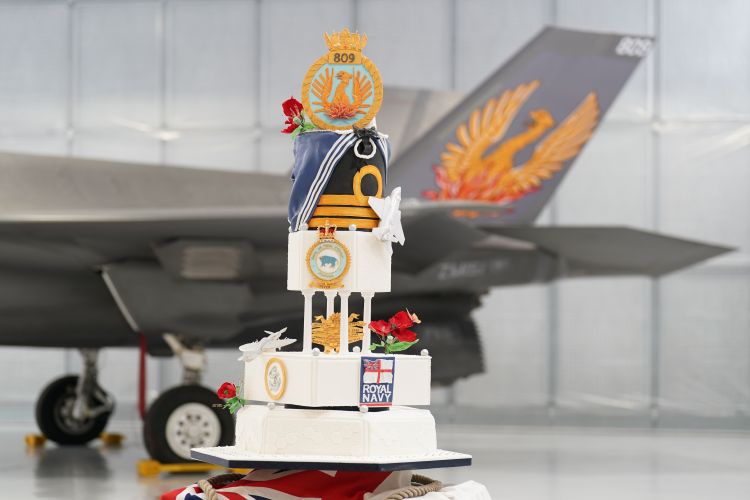 A cake sits in front of an F-35 Lightning stealth jet from 809 Naval Air Squadron during the commissioning ceremony at RAF Marham in Norfolk (Picture: PA Wire, PA Images).