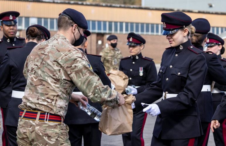 A member of the support team hands out lunches to a member of the British Army at Pirbright ahead of full dress rehearsal for the Duke of Edinburgh's funeral in London (Picture: MOD).