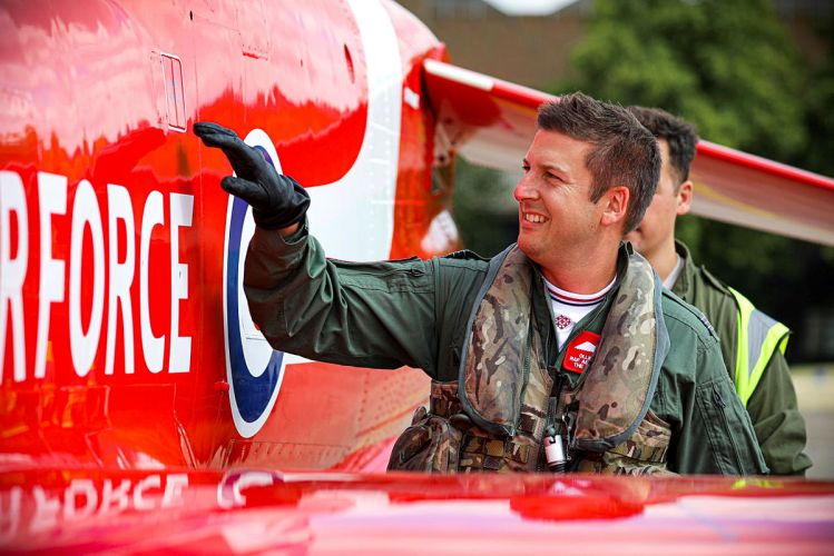 A new member of the Red Arrows next to one of the aircrafts