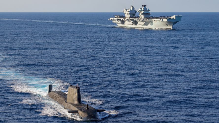 An Astute Class submarine (foreground) and HMS Queen Elizabeth (background) during the Carrier Strike Group 21 deployment (Picture: MOD).