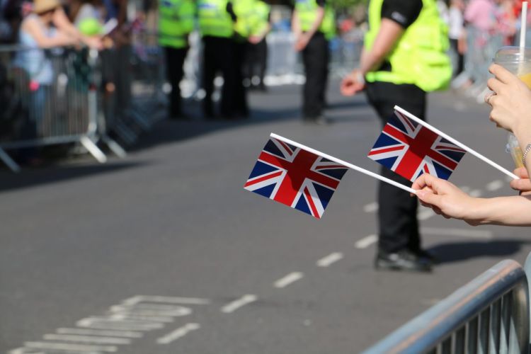 Anonymous hands holding Union flags British flags at Armed Forces Day