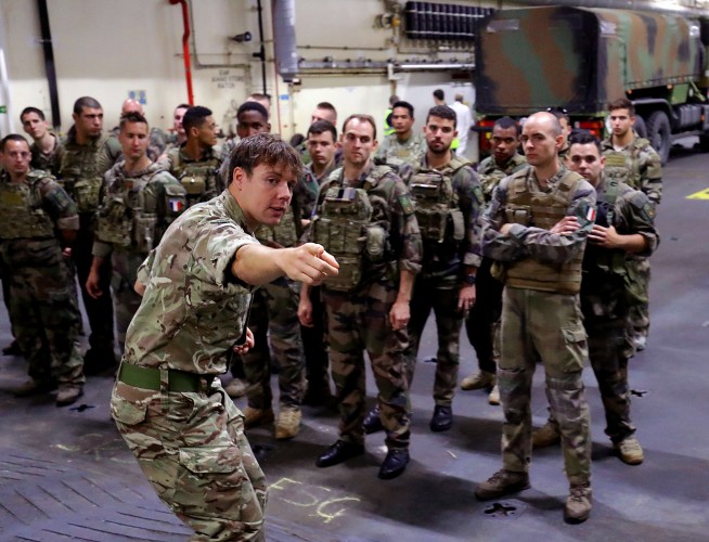 A British soldier briefing French troops inside the vehicle deck of RFA Lyme Bay. (Picture: Royal Navy)