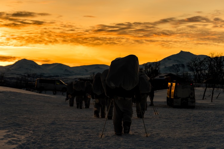 Troops Trek Through Snow As The Sun Sets On Exercise Clockwork