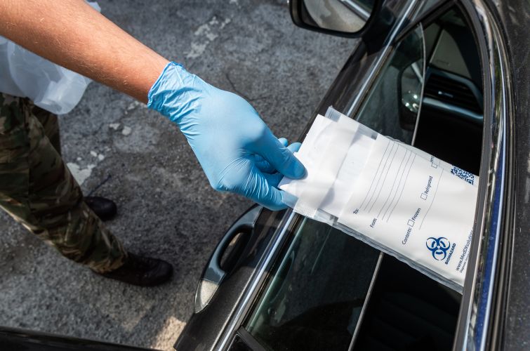 Coronavirus test kit is posted through the car window at the Mobile Testing Unit in Kenda
