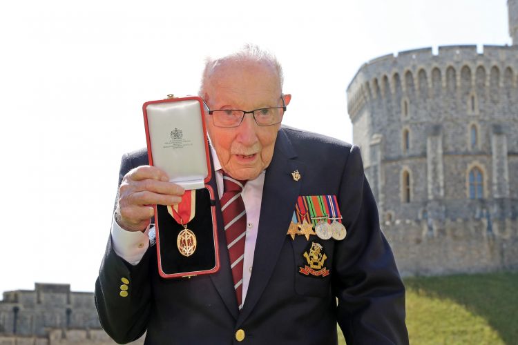 Capt Sir Tom shows off his medal after being knighted (Picture: PA).