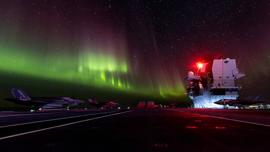 F-35B aircraft are seen here on the flight deck of HMS Prince of Wales, illuminated by the northern lights whilst off the coast of Norway (Picture: MOD)