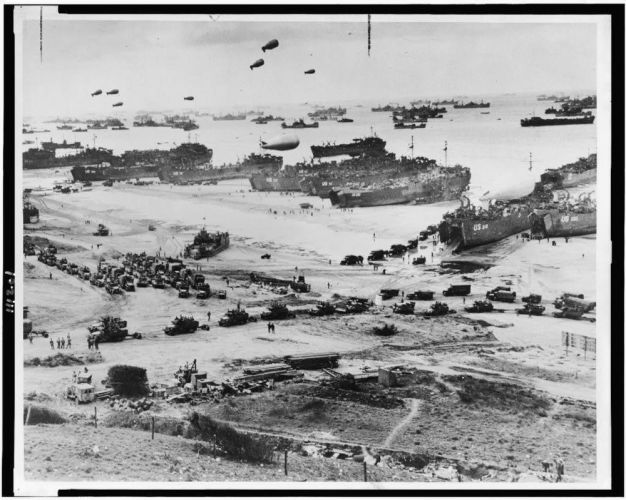 Landing craft, barrage balloons and allied troops assault a Normandy beach
