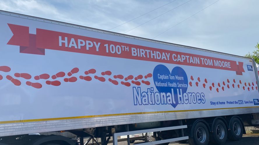 A large truck in Captain Tom Moore's village displays a birthday wishes message.