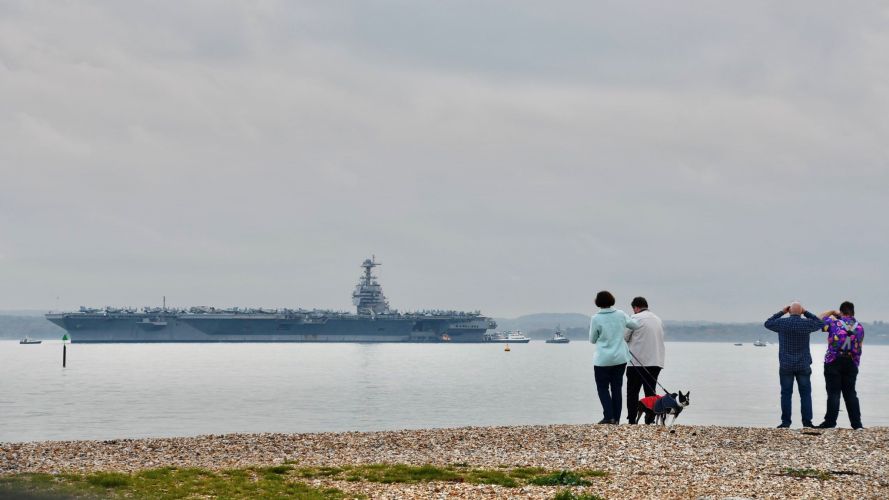 Locals watch the US Navy aircraft carrier, USS Gerald R Ford come into the Solent CREDIT Amy Savage, @AmyzJS13