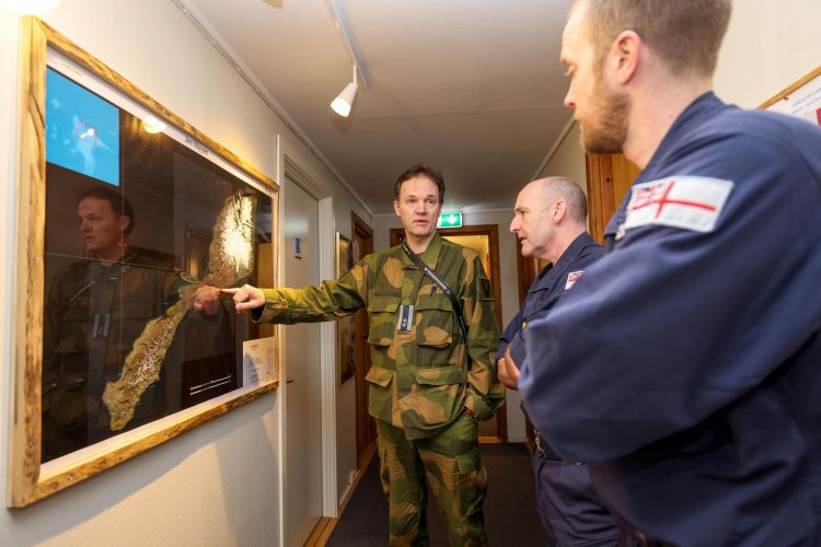 Norwegian personnel point at Jan Mayen map whilst with two Royal Navy personnel 130422 CREDIT Royal Navy