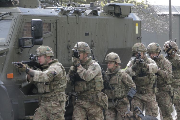 Soldiers hide behind the Foxhound.