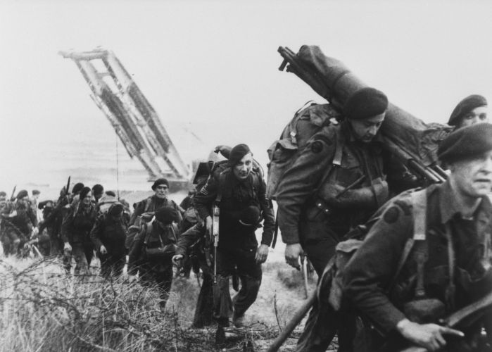 Royal Marine commandos move off a Normandy beach on D-Day 