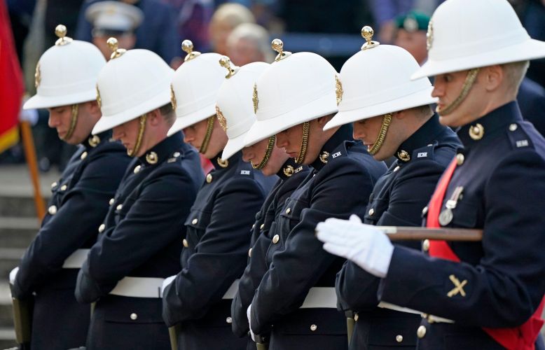 Royal Marines bow their heads as the coffin of Major General Matthew Holmes, the former head of the Royal Marines, is carried into Winchester Cathedral in Hampshire for his funeral