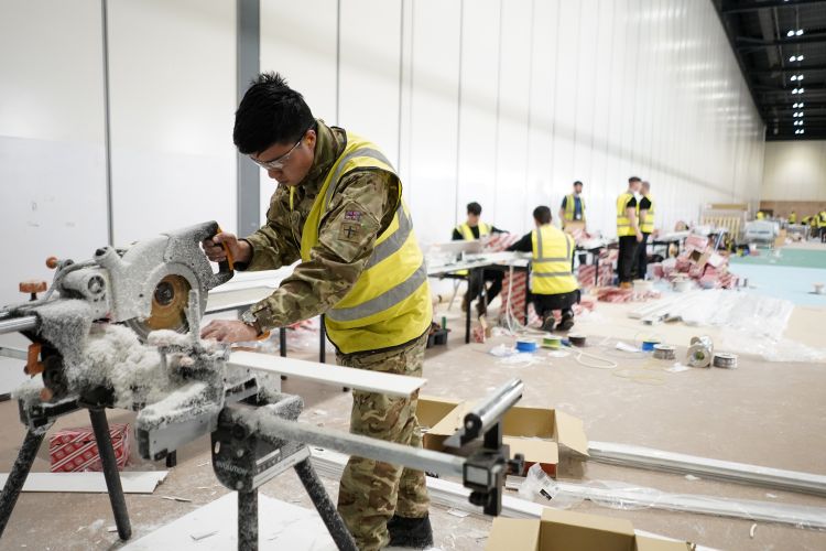 Soldier cuts material at NHS Nightingale 270320 CREDIT NUMBER 10:FLICKR.jpg 