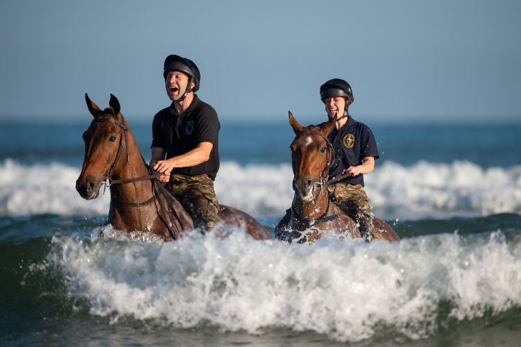 Soldiers and horses from The King's Troop Royal Horse Artillery exercise in the sea at Holkham in Norfolk