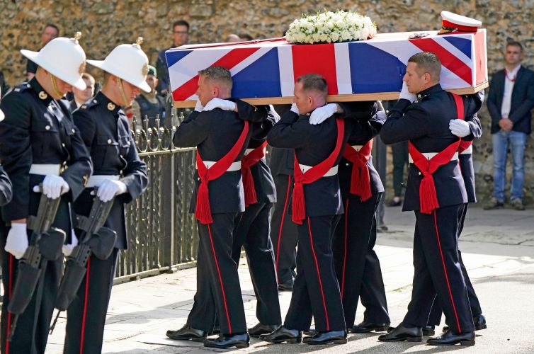 The coffin of Major General Matthew Holmes, former head of Royal Marines, is carried into Winchester Cathedral in Hampshire