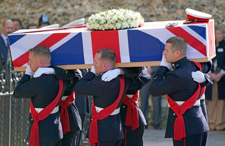 The coffin of Major General Matthew Holmes, former head of Royal Marines, is carried into Winchester Cathedral in Hampshire