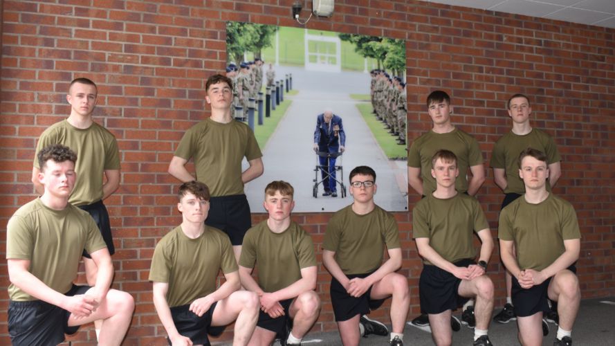 UK Armed Forces personnel pose in front of a picture of Captain Tom Moore amid efforts to take on the Captain Tom 100 challenge (Picture: MOD).