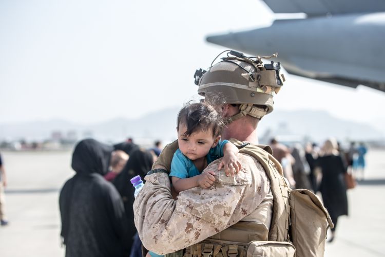 US Marine carries an infant