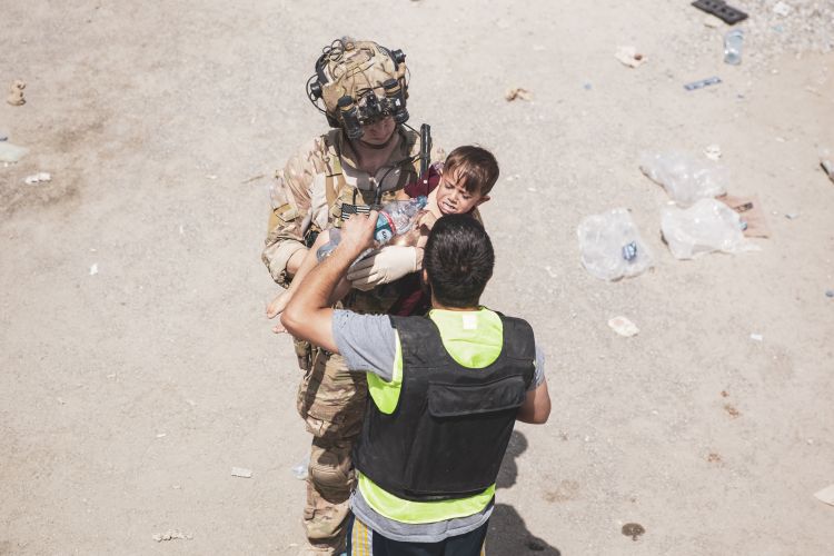 US service member carries a child during an evacuation at Kabul airport 