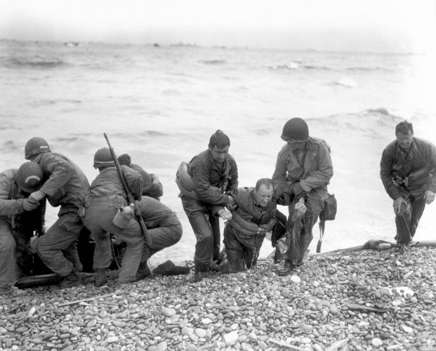 US personnel help injured soldiers ashore on Utah beach