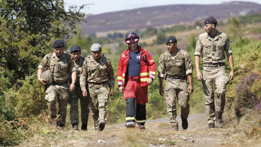 Soldiers from 10 Queen's Own Gurkha Logistic Regiment (10 QOGLR) walking the ground with one of the firefighters from South Wales Fire and Rescue (Picture: MOD) Army steps in to help with South Wales wildfires pic MOD