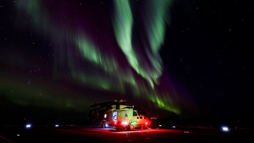  Engineers work on a Merlin helicopter being treated to a stunning display of Aurora Borealis (Picture: MOD).
