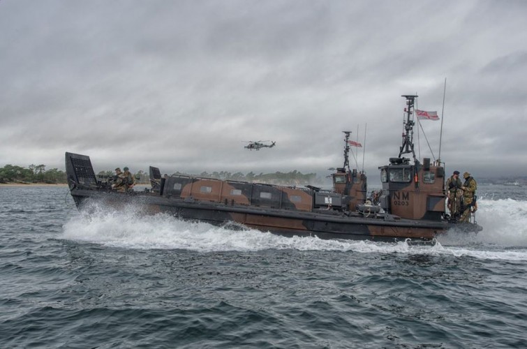 A Wildcat helicopter flies alongside in support