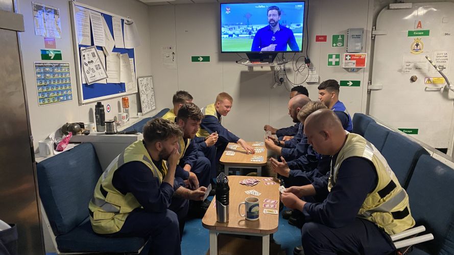 Navy personnel spend some of their free time playing cards.