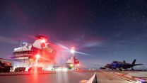 The flight deck of HMS Prince of Wales at night while conducting simultaneous rotary and fixed-wing night flying operations with US F-35s embarked