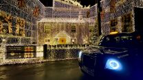 A black London taxi in front of the decorated house 