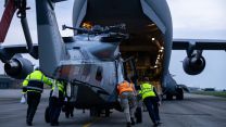 A Royal Navy Wildcat helicopter is loaded onto a RAF C-17 before it departs to bolster defences in Cyprus