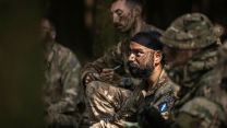 The signallers take notes as they attend an O Group the night before launching their deliberate attack on the enemy position - every little detail matters