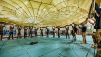 Soldiers from the French 11e Brigade Parachutiste are shown the size of a low-level parachute by Army Parachute Jump Instructors during a joint training exercise in Oxfordshire
