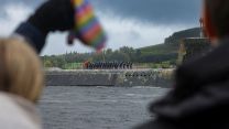 Submariners aboard the Vanguard Class submarine wave to loved ones as she comes in to dock