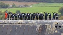 Submariners aboard the Vanguard Class submarine wave to loved ones as she comes in to dock