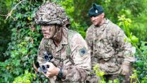 A competitor works his way through the sword lane under the watchful eye of a Royal Irish Regiment instructor, who is assessing his progress while making sure he stays safe