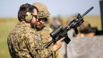 A soldier from 3rd Battalion Princess Patricia's Canadian Light Infantry gives instruction on a Colt C7 weapon system to a British paratrooper from 16 Air Assault Brigade during Exercise Rhino Bizz in Suffield