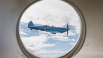 A Spitfire TR9 is snapped through the cabin window of a P-8A Poseidon as it makes its way round Britain as part of the Spitfire90 anniversary tour