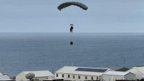 The para controls the canopy as he brings in the medic - the extra kit suspended from the rope will hit the ground first