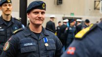  A Norwegian member of personnel stands proudly with his medal 