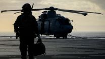 A crew member from 814 Naval Air Squadron walks out to their Merlin Mk2 on board HMS Prince of Wales during Operation Firecrest in the High North