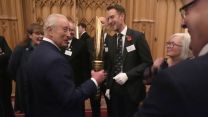 King Charles holding torch of peace from CWGC at a reception for veterans who served in Pacific during WW2