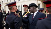 A Master Tailor inspects the uniforms of some Royal Artillery soldiers at Wellington Barracks - Master Tailors, often veterans, specialise in bespoke military uniforms for officers and senior NCOs