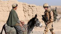 Prince Harry passes a donkey while on patrol through the deserted town of Garmsir, Afghanistan (Picture: PA Images)