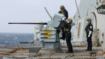 Personnel wearing protective clothing operate one of the 30mm Small Calibre Guns during live firing gunnery serials on board HMS Dragon - the crew also tested the Phalanx close-in weapon systems
