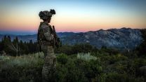 A commando from Air Defence Troop, 29 Commando, surveys the ground in low light while deployed to the Mountain Warfare Training Centre at Pickel Meadows in California