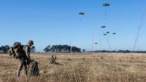 A soldier, with his bergen already on his back, packs away his parachute after landing on the drop zone at  the St Cyr-Coëtquidan training area (Picture: MOD) 