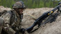 A GPMG gunner from 3 Para shares a joke while manning his firing position alongside soldiers from Finland's Kainuu Brigade on Exercise Northern Star, less than 80 miles from the Russian border